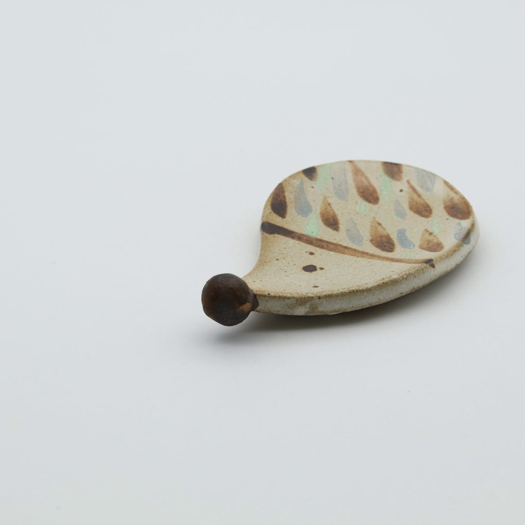 ハリネズミを模った小ぶりなやちむんの豆皿。茶色のドットで針が表現されており、つぶらな瞳と突き出した鼻が特徴的な、カトラリーレストにもなる｢土の種」の作品。