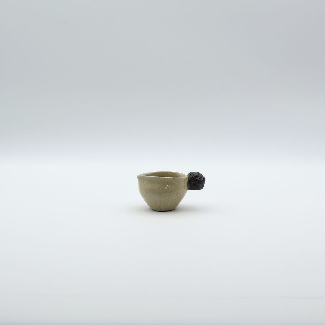 「岩」をモチーフにした持ち手が特徴的な、沖縄「土の種」のミルクピッチャー。自然の力強さと温かさを感じさせる、土の種を代表するやちむんのオリジナル作品。