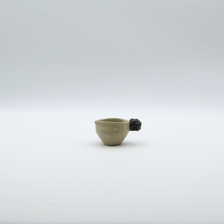 「岩」をモチーフにした持ち手が特徴的な、沖縄「土の種」のミルクピッチャー。自然の力強さと温かさを感じさせる、土の種を代表するやちむんのオリジナル作品。