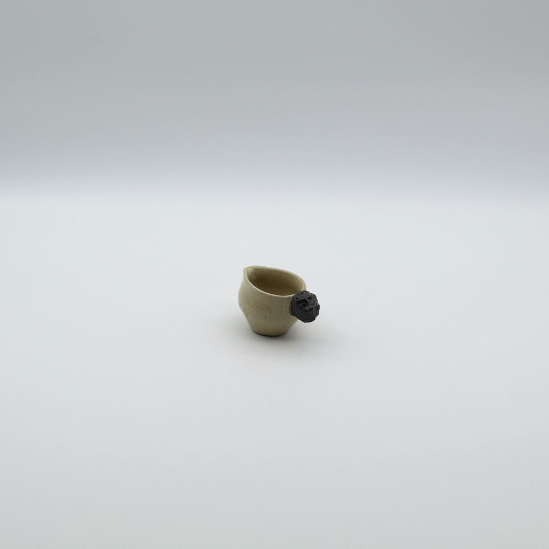 「岩」をモチーフにした持ち手が特徴的な、沖縄「土の種」のミルクピッチャー。自然の力強さと温かさを感じさせる、土の種を代表するやちむんのオリジナル作品。