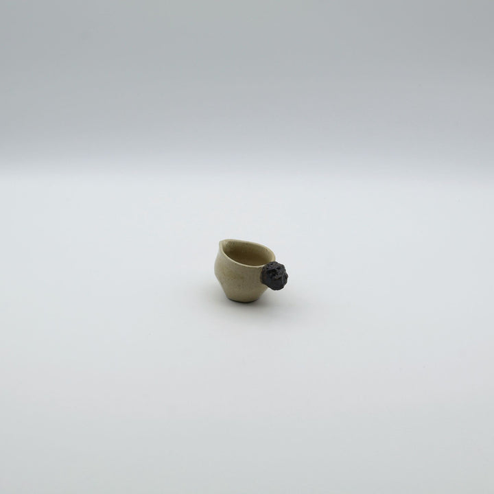 「岩」をモチーフにした持ち手が特徴的な、沖縄「土の種」のミルクピッチャー。自然の力強さと温かさを感じさせる、土の種を代表するやちむんのオリジナル作品。