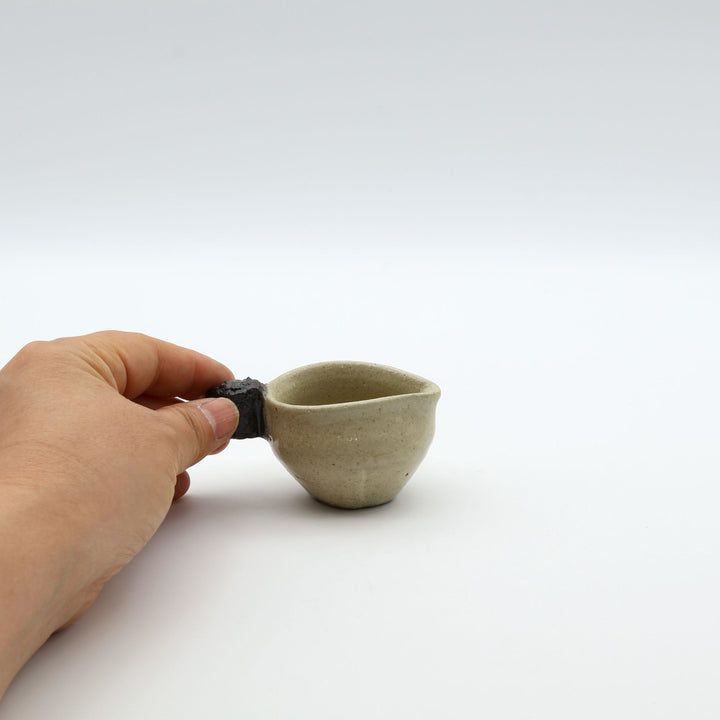 ゴツゴツとした岩のような黒い持ち手がついた、陶器製ミルクピッチャー。手仕事ならではの質感と適度な遊び心が魅力的な、小ぶりの器。自然の力強さと温かさを感じさせる、土の種を代表するやちむんの定番作品。