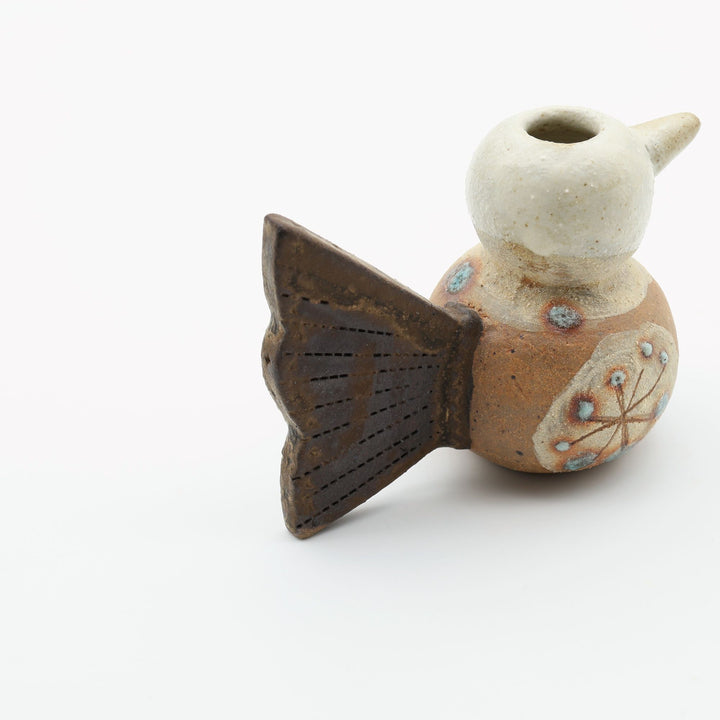 沖縄のやちむん「土の種」による鳥の形をしたミニ花器。小鳥の愛らしいシルエットと、手描きのお花模様が特徴的な、温もりある陶器の一輪挿し。