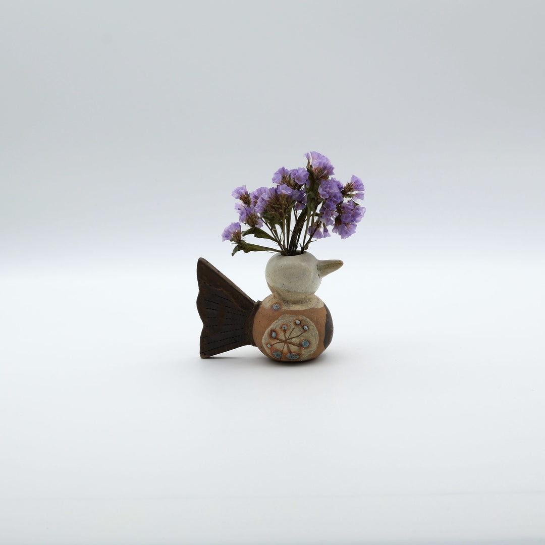 沖縄のやちむん「土の種」による鳥の形をしたミニ花器。小鳥の愛らしいシルエットと、手描きのお花模様が特徴的な、温もりある陶器の一輪挿し。