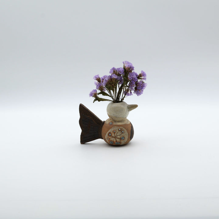 沖縄のやちむん「土の種」による鳥の形をしたミニ花器。小鳥の愛らしいシルエットと、手描きのお花模様が特徴的な、温もりある陶器の一輪挿し。