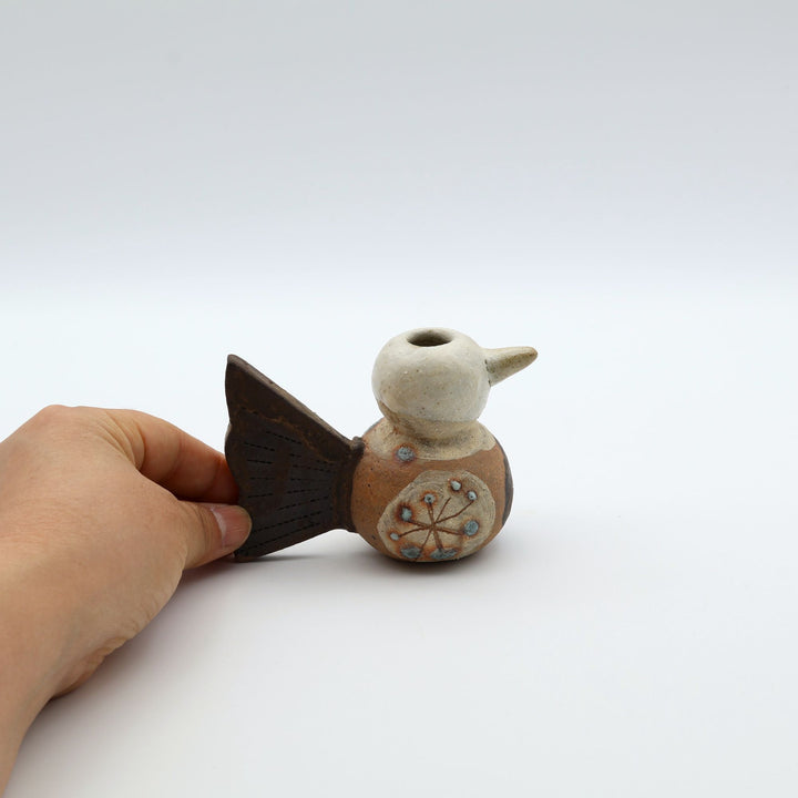 沖縄のやちむん「土の種」による鳥の形をしたミニ花器。小鳥の愛らしいシルエットと、手描きのお花模様が特徴的な、温もりある陶器の一輪挿し。