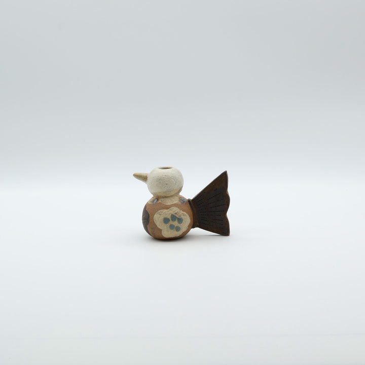 沖縄のやちむん「土の種」による鳥の形をしたミニ花器。小鳥の愛らしいシルエットと、手描きのお花模様が特徴的な、温もりある陶器の一輪挿し。