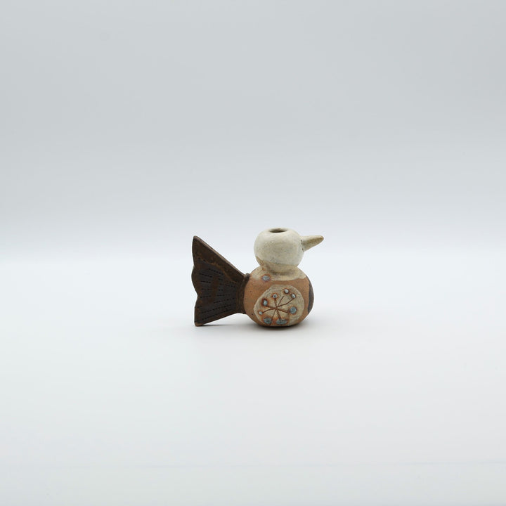沖縄のやちむん「土の種」による鳥の形をしたミニ花器。小鳥の愛らしいシルエットと、手描きのお花模様が特徴的な、温もりある陶器の一輪挿し。