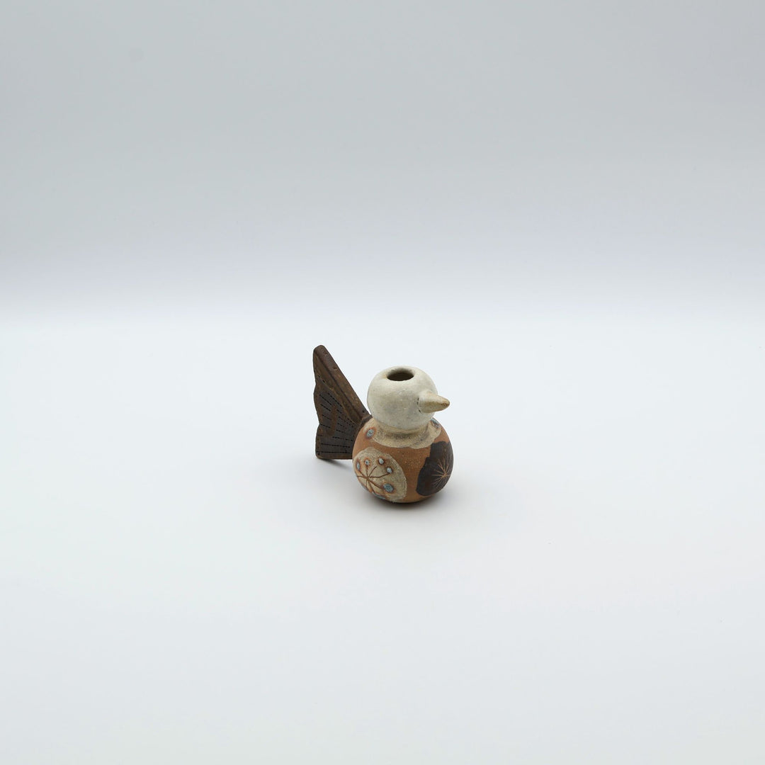 沖縄のやちむん「土の種」による鳥の形をしたミニ花器。小鳥の愛らしいシルエットと、手描きのお花模様が特徴的な、温もりある陶器の一輪挿し。