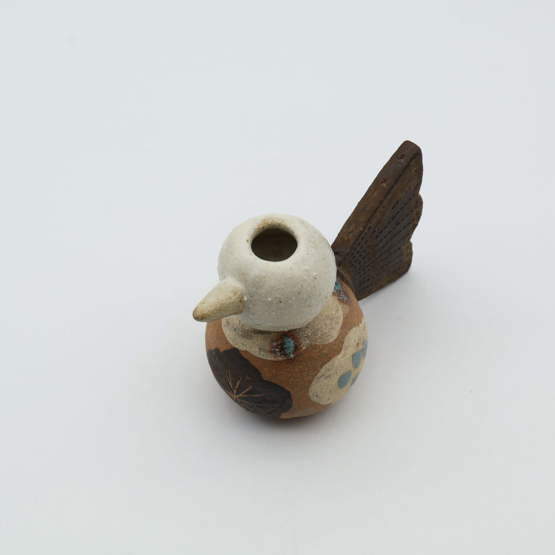 沖縄のやちむん「土の種」による鳥の形をしたミニ花器。小鳥の愛らしいシルエットと、手描きのお花模様が特徴的な、温もりある陶器の一輪挿し。