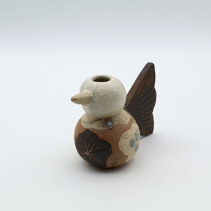 沖縄のやちむん「土の種」による鳥の形をしたミニ花器。小鳥の愛らしいシルエットと、手描きのお花模様が特徴的な、温もりある陶器の一輪挿し。