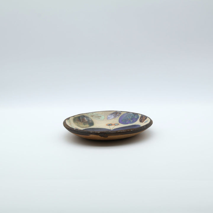 沖縄のやちむん工房「土の種」のサラダ皿。鮮やかなコバルトブルーの蝶が大胆に絵付けされた手仕事の平皿。