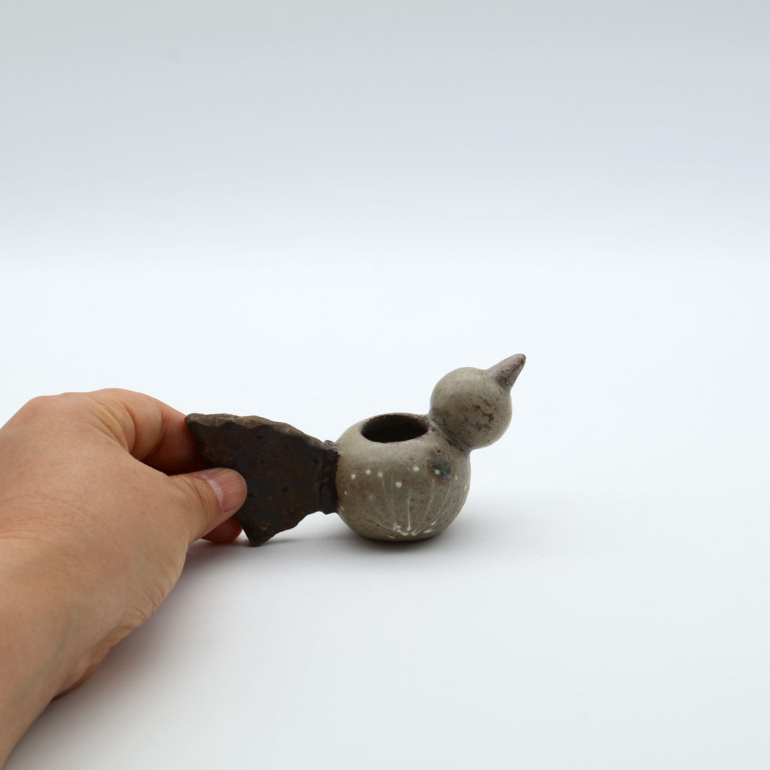 沖縄のやちむん作家「土の種」による、コロンとした鳥の形をした愛らしいミニ花器（一輪挿し・楊枝入れ）。背中に穴が開いており、素朴な土の風合いとオブジェとしての可愛らしさを併せ持つ陶器。