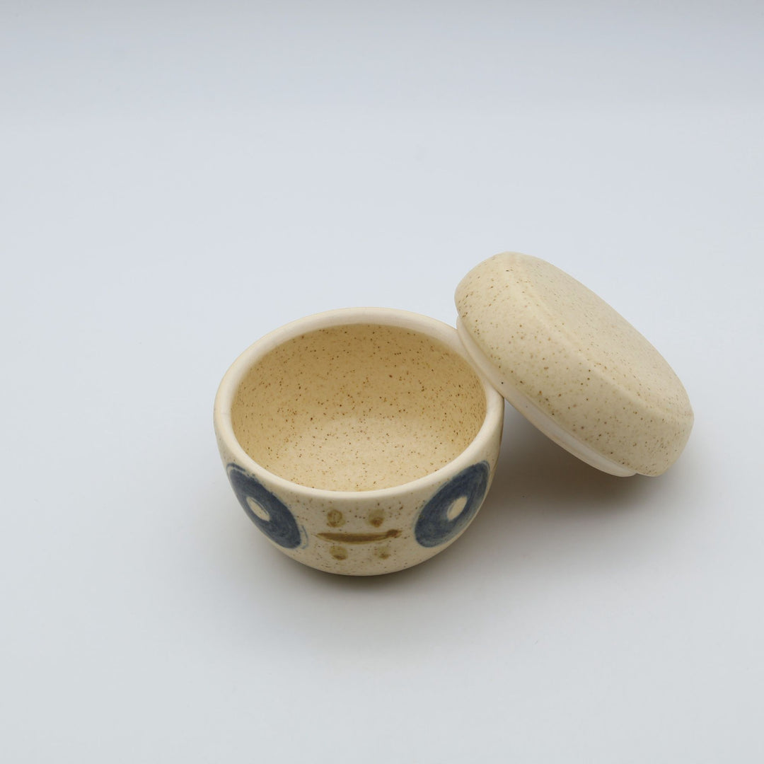 sora potters workによる、温かみのあるベージュの器肌に伝統的なやちむん柄をSPW風にアレンジしたモダンな模様が描かれた小さな蓋物。