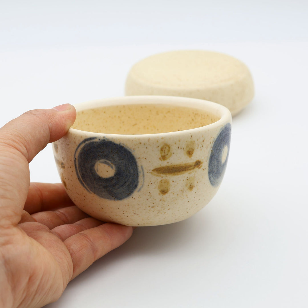 sora potters workによる、温かみのあるベージュの器肌に伝統的なやちむん柄をSPW風にアレンジしたモダンな模様が描かれた小さな蓋物。