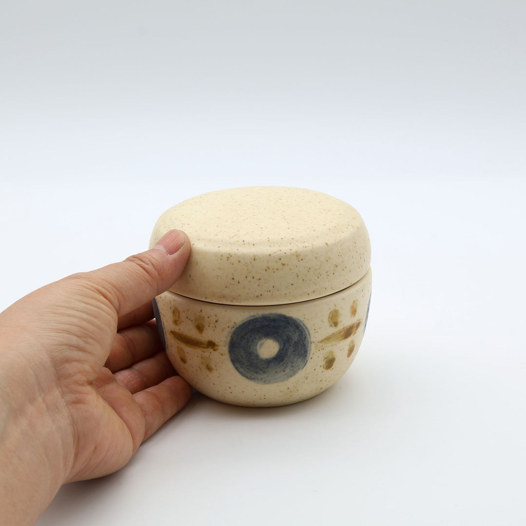 sora potters workによる、温かみのあるベージュの器肌に伝統的なやちむん柄をSPW風にアレンジしたモダンな模様が描かれた小さな蓋物。