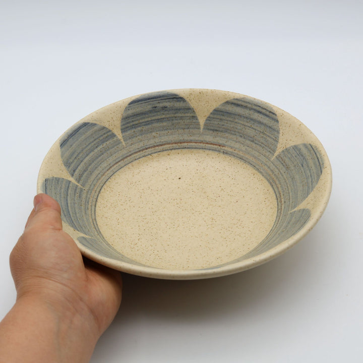 sora potters workによる、縁に淡いブルーグレーの丸花模様が配されたベージュ・生成り系のやちむん盛皿。パスタやチャンプルー、シチュー、サラダボウルに重宝するシンプルな暮らしの器。