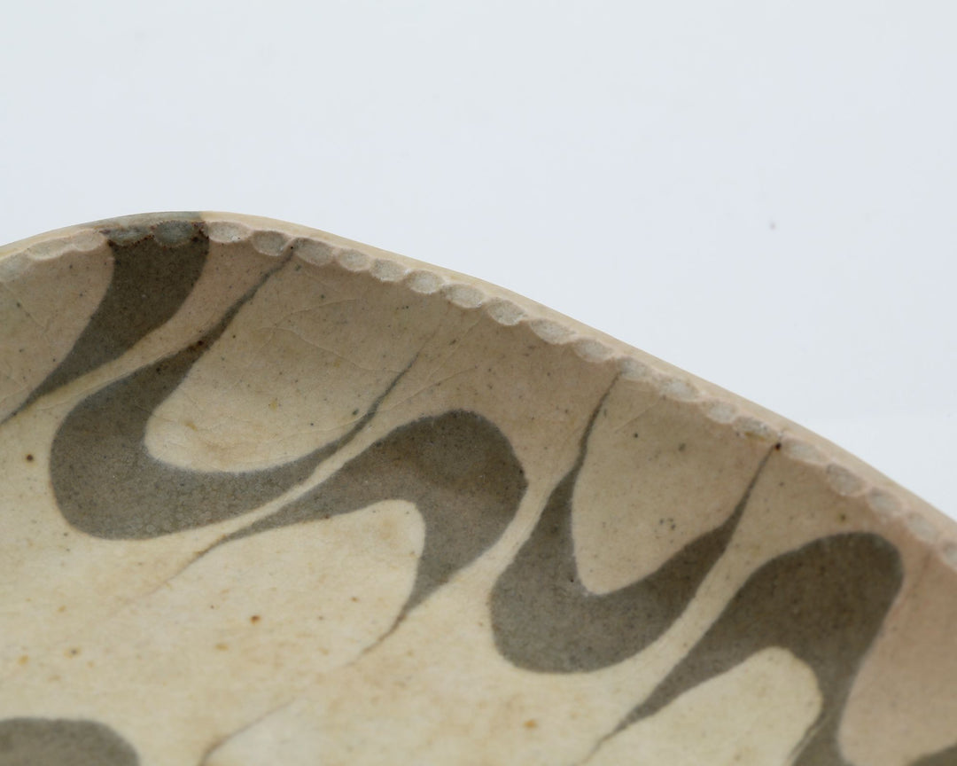 宋艸窯（そうそうがま）が異なる色の粘土を組み合わせて作った、練り込み技法の長方形の小皿。白背景の中央に置かれた、モダンな幾何学模様と丸みのあるフォルムが美しい手仕事の豆皿です。