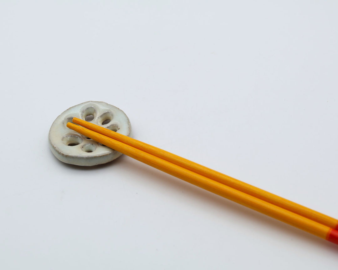 鹿児島県の宋艸窯（そうそうがま）が丁寧な手仕事で手がけた、レンコン（蓮根）を模した可愛い陶器の箸置き。素朴な穴模様と丸みのある温かみ溢れる佇まいが魅力的な和食器の小物です。