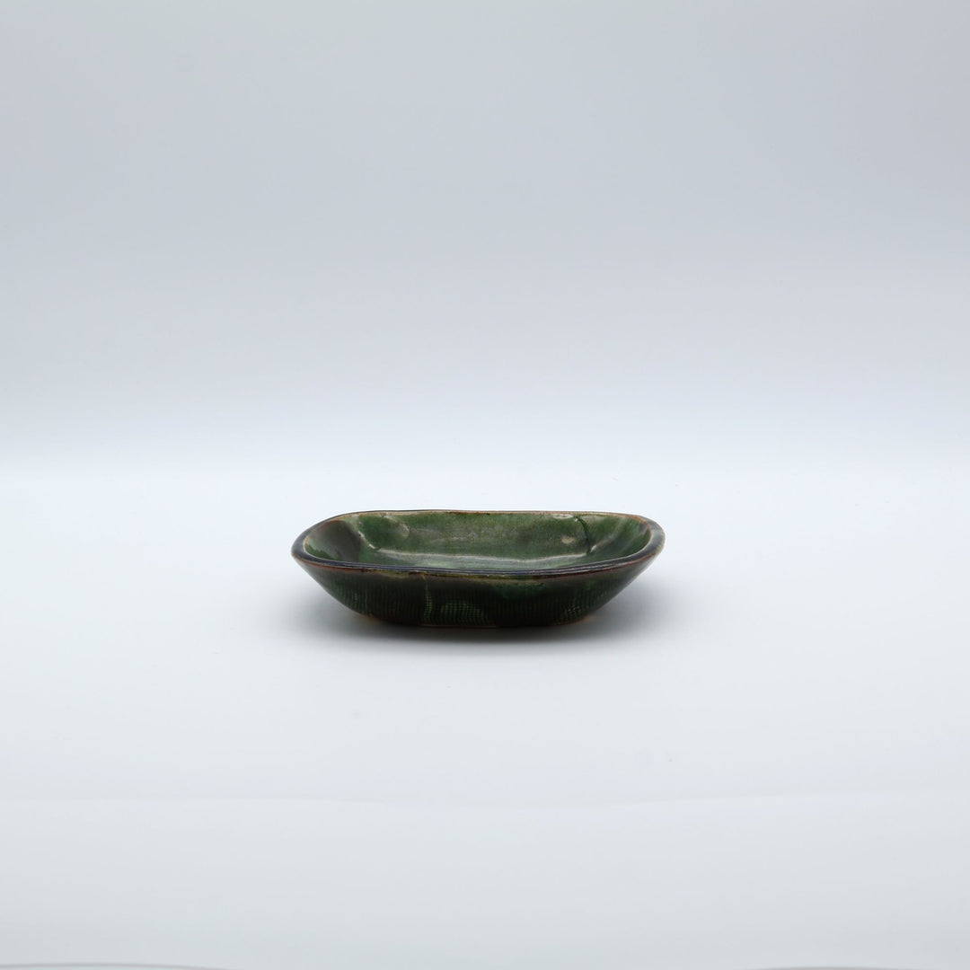 宋艸窯（そうそうがま）が異なる色の粘土を組み合わせて作った、練り込み技法に緑釉を表面に施した長方形の小皿。緑釉越しに見える練り込みの幾何学模様と丸みのあるフォルムが美しい手仕事の角小皿です。