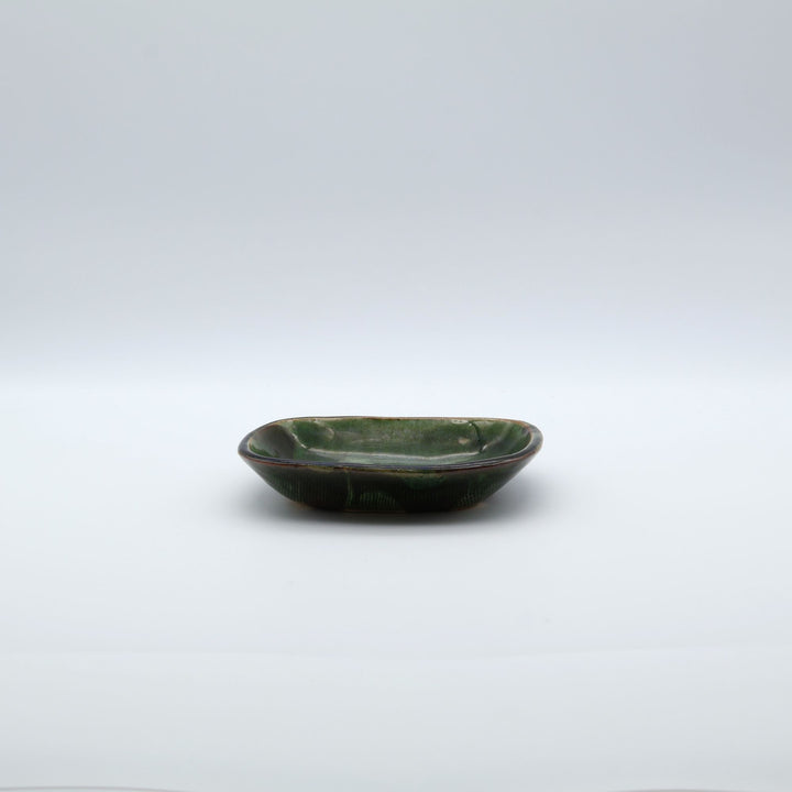 宋艸窯（そうそうがま）が異なる色の粘土を組み合わせて作った、練り込み技法に緑釉を表面に施した長方形の小皿。緑釉越しに見える練り込みの幾何学模様と丸みのあるフォルムが美しい手仕事の角小皿です。