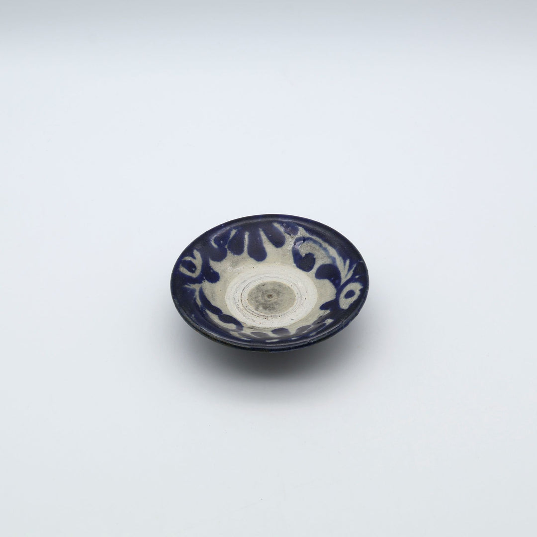 横田屋窯（やちむん）の3寸豆皿。中央に登り窯焼成の証である白い「蛇の目」があり、縁には呉須の唐草模様が施された普段使いの豆皿。