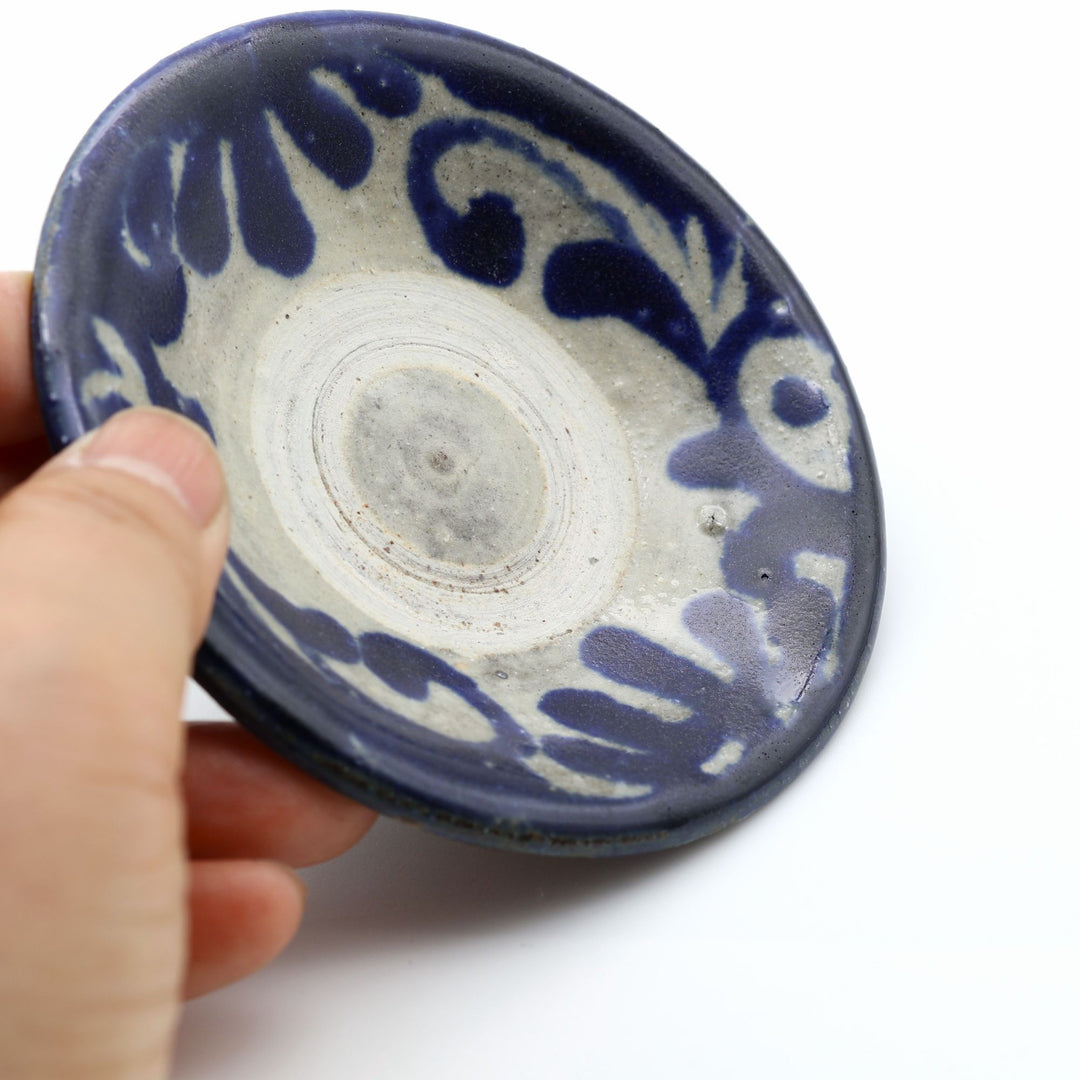 横田屋窯（やちむん）の3寸豆皿。中央に登り窯焼成の証である白い「蛇の目」があり、縁には呉須の唐草模様が施された普段使いの豆皿。