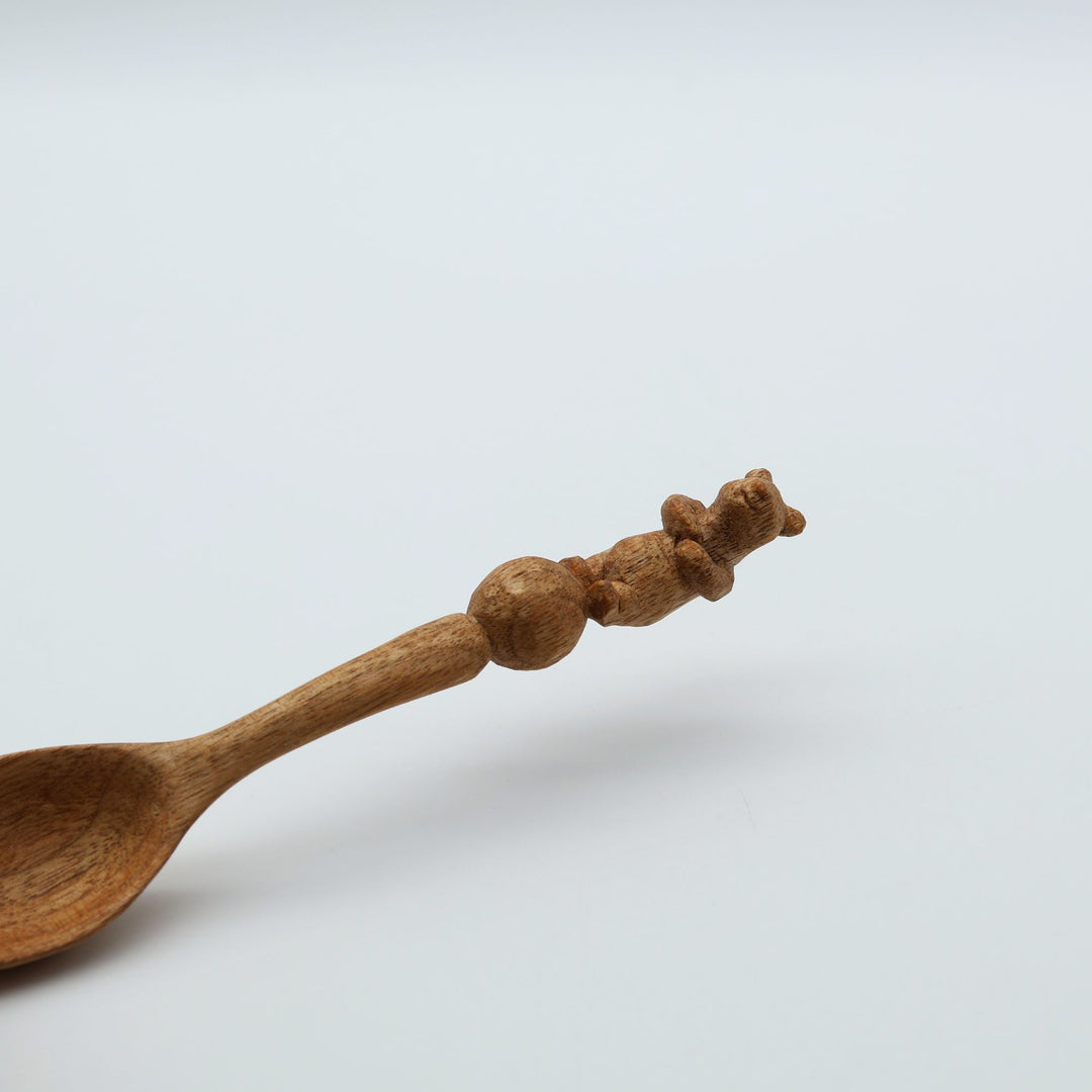 北海道の作家、木工YOUSUN（ヨウサン）が地元のクルミを丁寧に削り出して作った木製コーヒースプーン。柄の先端に上手な玉乗りをする可愛いクマが彫られた、手仕事の温かみを感じるカトラリーです。