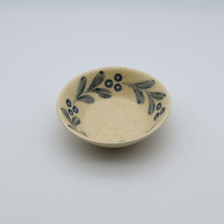 sora potters workによる、温かみのあるベージュの器肌にのびやかな葉と実の植物紋が描かれた手作りの4寸深皿（小鉢）