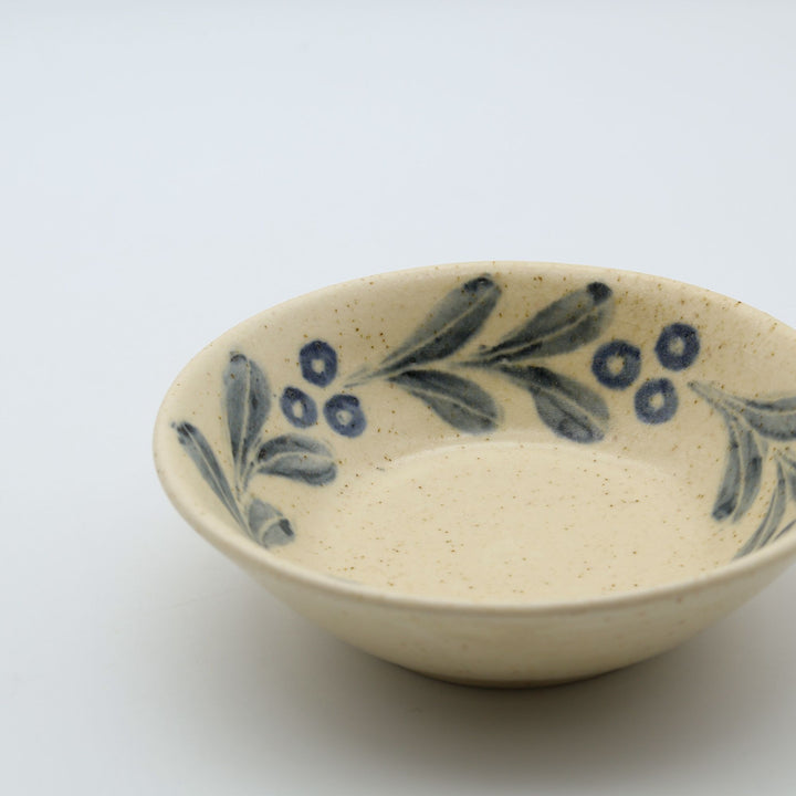 sora potters workによる、温かみのあるベージュの器肌にのびやかな葉と実の植物紋が描かれた手作りの4寸深皿（小鉢）