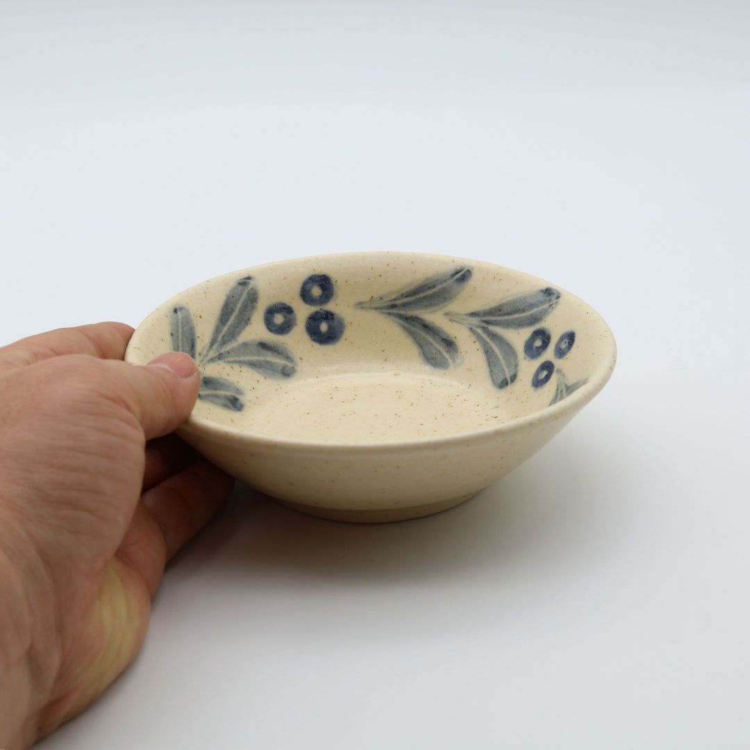 sora potters workによる、温かみのあるベージュの器肌にのびやかな葉と実の植物紋が描かれた手作りの4寸深皿（小鉢）