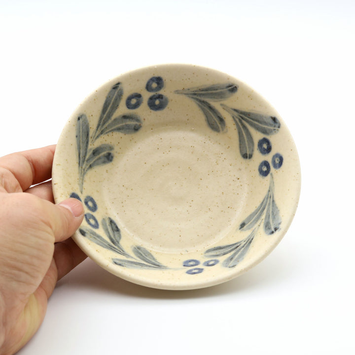 sora potters workによる、温かみのあるベージュの器肌にのびやかな葉と実の植物紋が描かれた手作りの4寸深皿（小鉢）