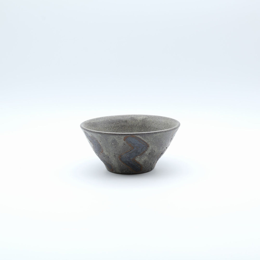 sora potters workによる、ザラりとした渋い鉄砂の器肌にジグザグの線紋が大胆に描かれた手作りのマカイ（お茶碗）。