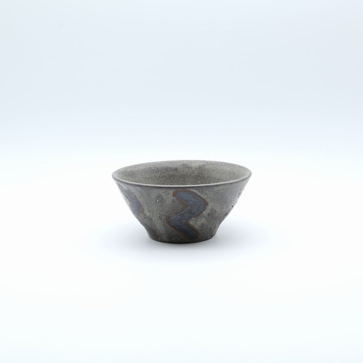 sora potters workによる、ザラりとした渋い鉄砂の器肌にジグザグの線紋が大胆に描かれた手作りのマカイ（お茶碗）。