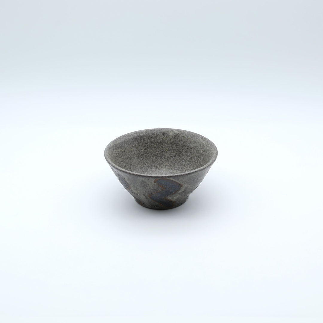 sora potters workによる、ザラりとした渋い鉄砂の器肌にジグザグの線紋が大胆に描かれた手作りのマカイ（お茶碗）。