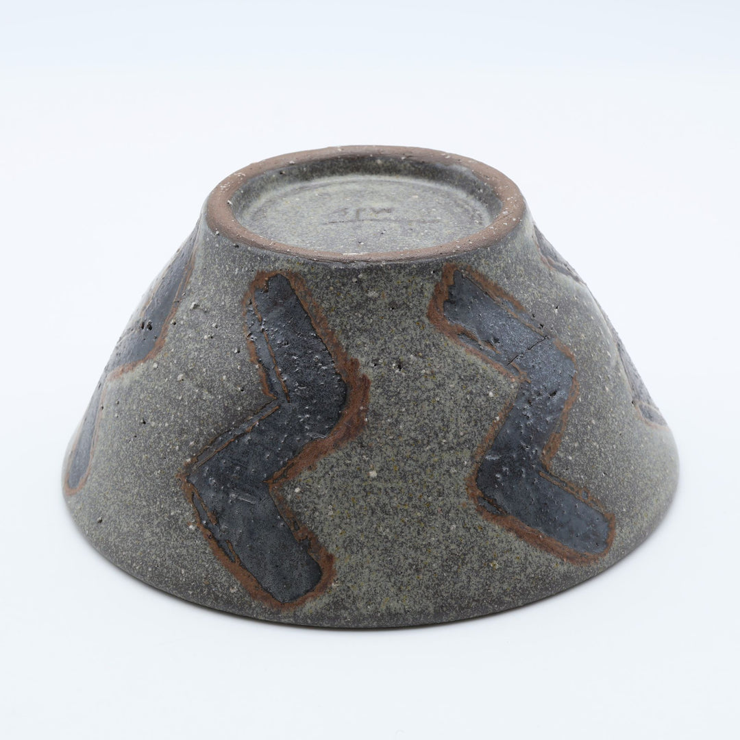 sora potters workによる、ザラりとした渋い鉄砂の器肌にジグザグの線紋が大胆に描かれた手作りのマカイ（お茶碗）。
