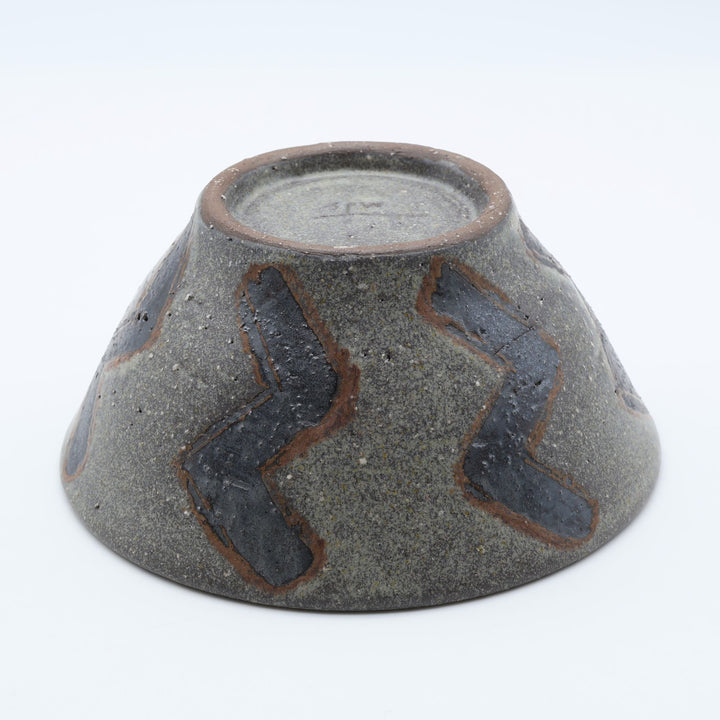 sora potters workによる、ザラりとした渋い鉄砂の器肌にジグザグの線紋が大胆に描かれた手作りのマカイ（お茶碗）。