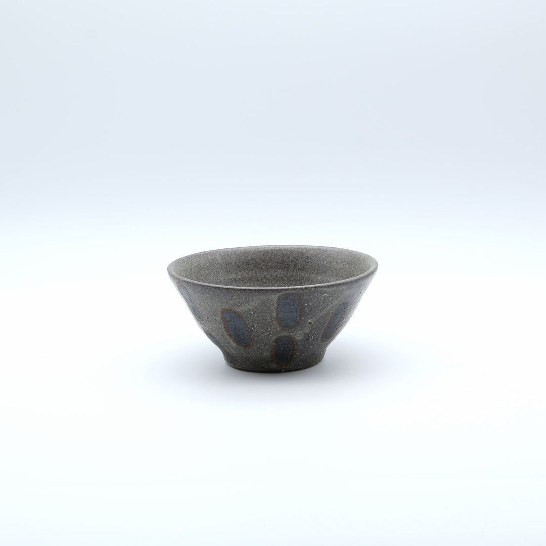 sora potters workによる、ザラりとした渋い鉄砂の器肌に点打ち紋が大胆に描かれた手作りのマカイ（お茶碗）。