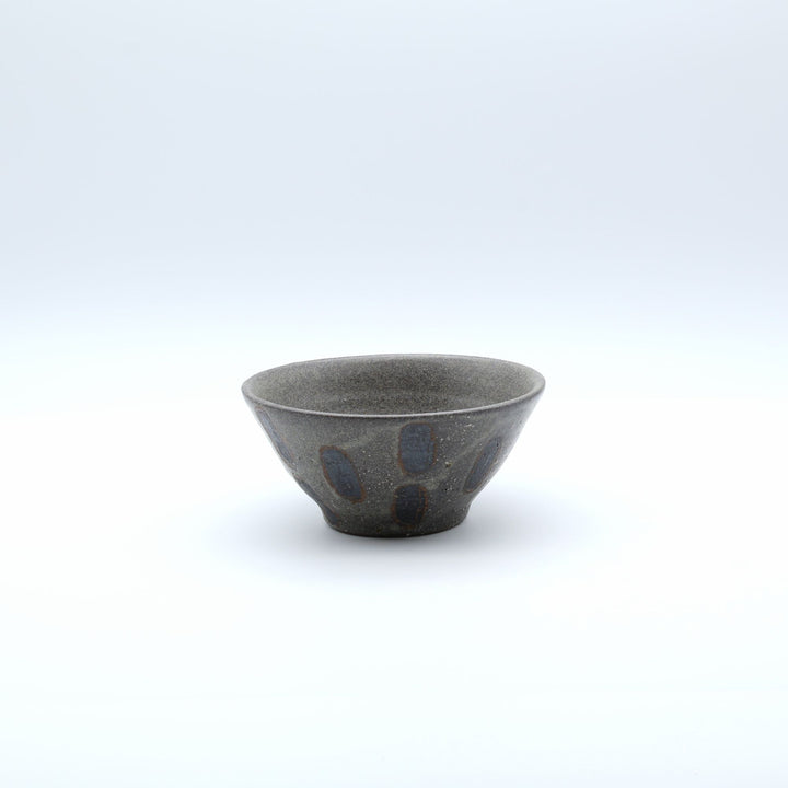 sora potters workによる、ザラりとした渋い鉄砂の器肌に点打ち紋が大胆に描かれた手作りのマカイ（お茶碗）。