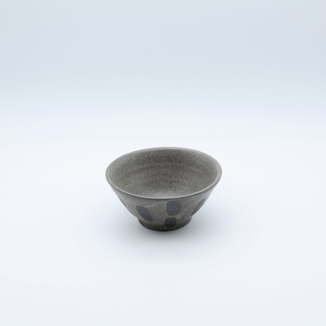 sora potters workによる、ザラりとした渋い鉄砂の器肌に点打ち紋が大胆に描かれた手作りのマカイ（お茶碗）。