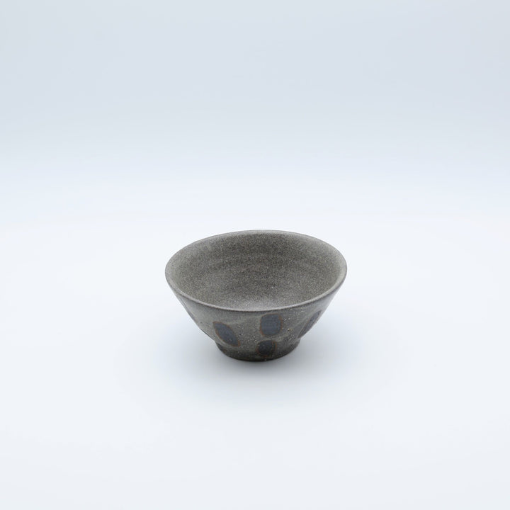 sora potters workによる、ザラりとした渋い鉄砂の器肌に点打ち紋が大胆に描かれた手作りのマカイ（お茶碗）。