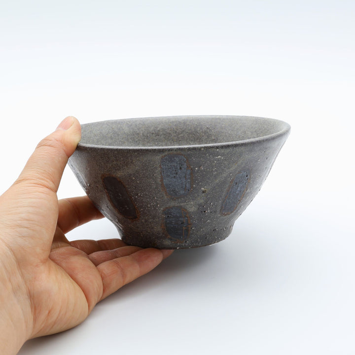 sora potters workによる、ザラりとした渋い鉄砂の器肌に点打ち紋が大胆に描かれた手作りのマカイ（お茶碗）。