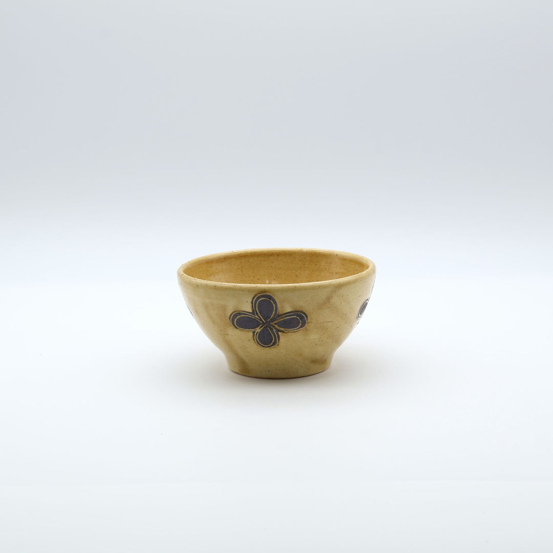 sora potters workによる、温かみのあるベージュの器肌十字花模様が描かれた手作りのお茶碗-マカイ