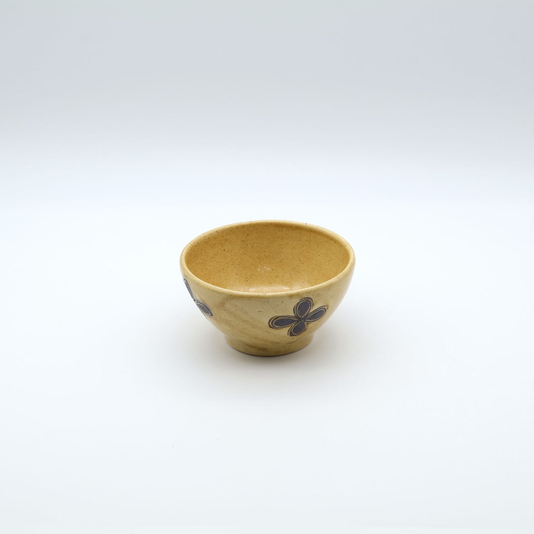 sora potters workによる、温かみのあるベージュの器肌十字花模様が描かれた手作りのお茶碗-マカイ