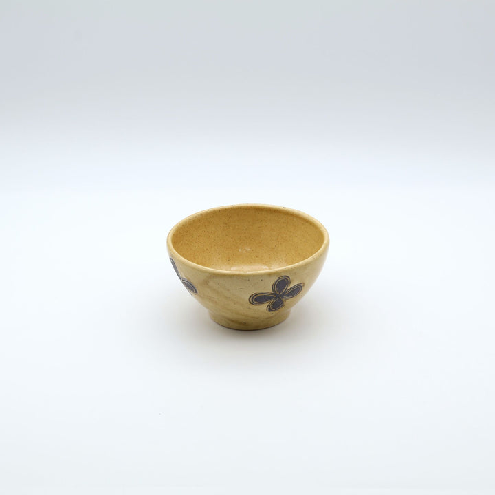 sora potters workによる、温かみのあるベージュの器肌十字花模様が描かれた手作りのお茶碗-マカイ