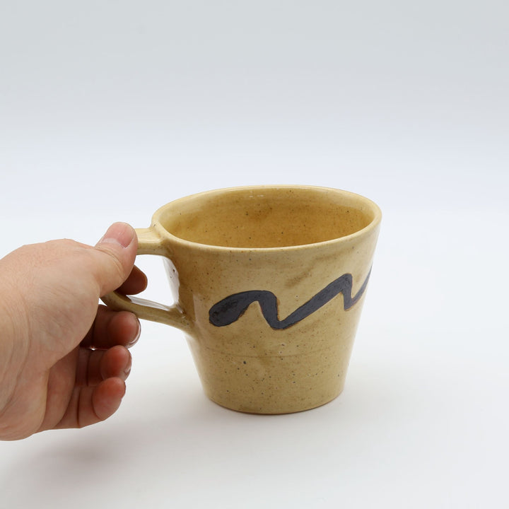 沖縄のsora potters workによる、はちみつ色に波模様が施されたやちむんの大きめマグカップ
