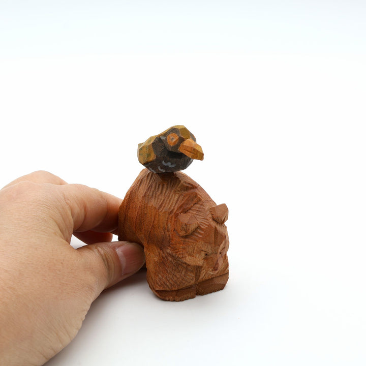 岐阜の木彫り熊作家「gizakuma」が彫る、背中に沖縄の飛べない鳥「ヤンバルクイナ」を乗せた、優しく真面目な表情をした手彫りの木製オブジェ。