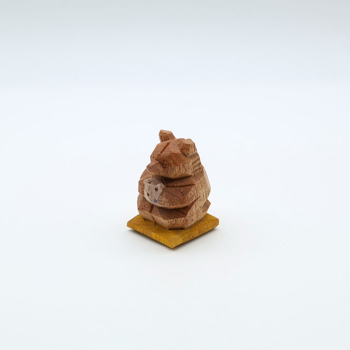岐阜の木彫り熊作家「gizakuma」が彫る、大切そうに「やちむん」の湯呑みでお茶を飲んでいる「くま」。座布団の上でほっと一息ついてリラックスしている手彫りの木製オブジェ。