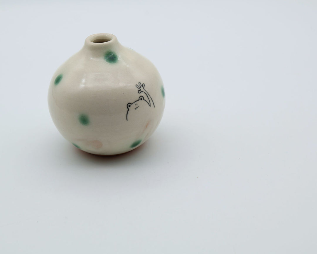 カエルのイラストと緑の織部釉ドットが描かれた、手のひらサイズの丸い萩焼楓窯の花入れ