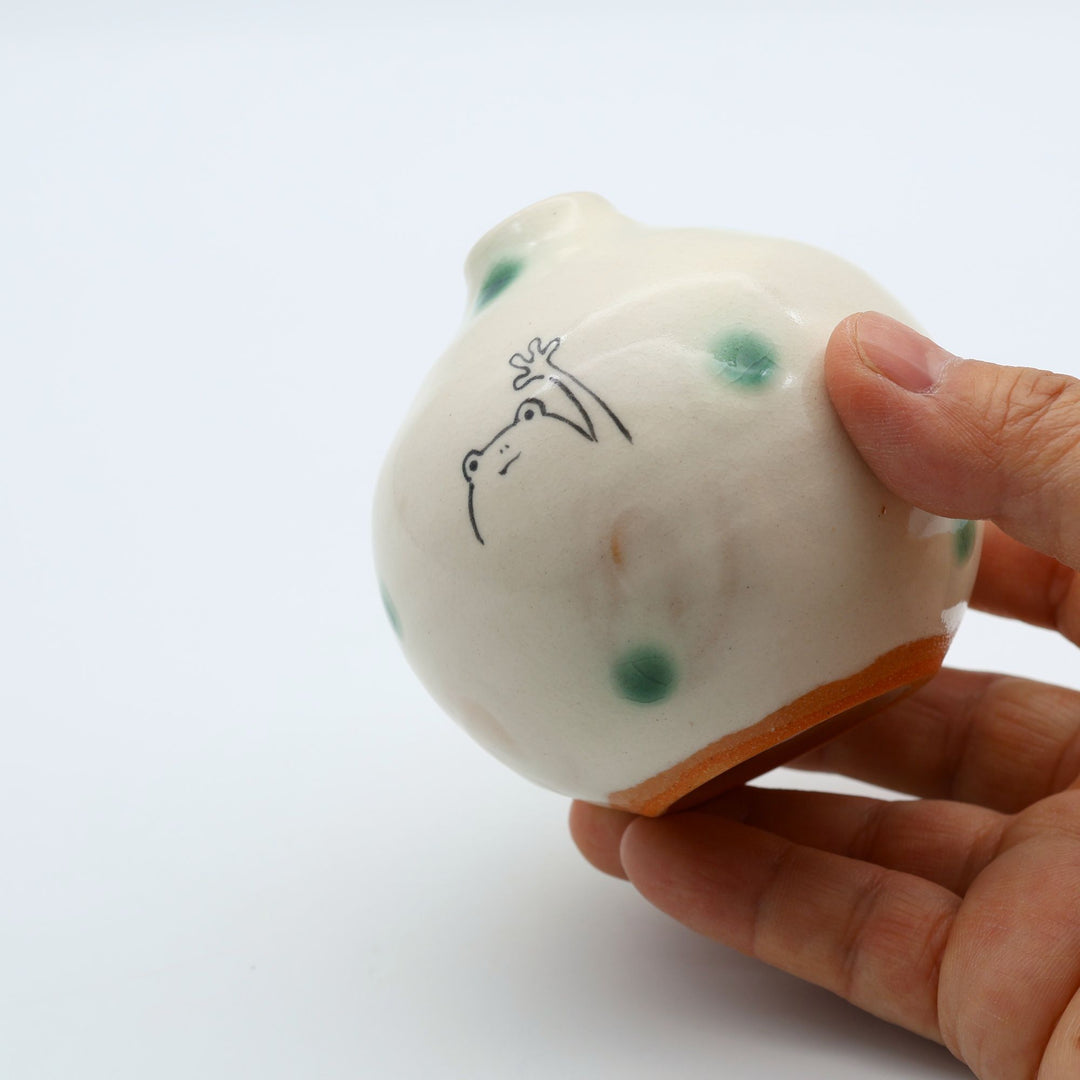 カエルのイラストと緑の織部釉ドットが描かれた、手のひらサイズの丸い萩焼楓窯の花入れ